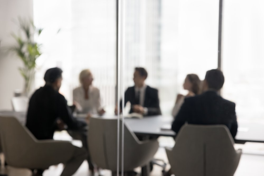 Group of businesspeople negotiating gathered in modern conference room